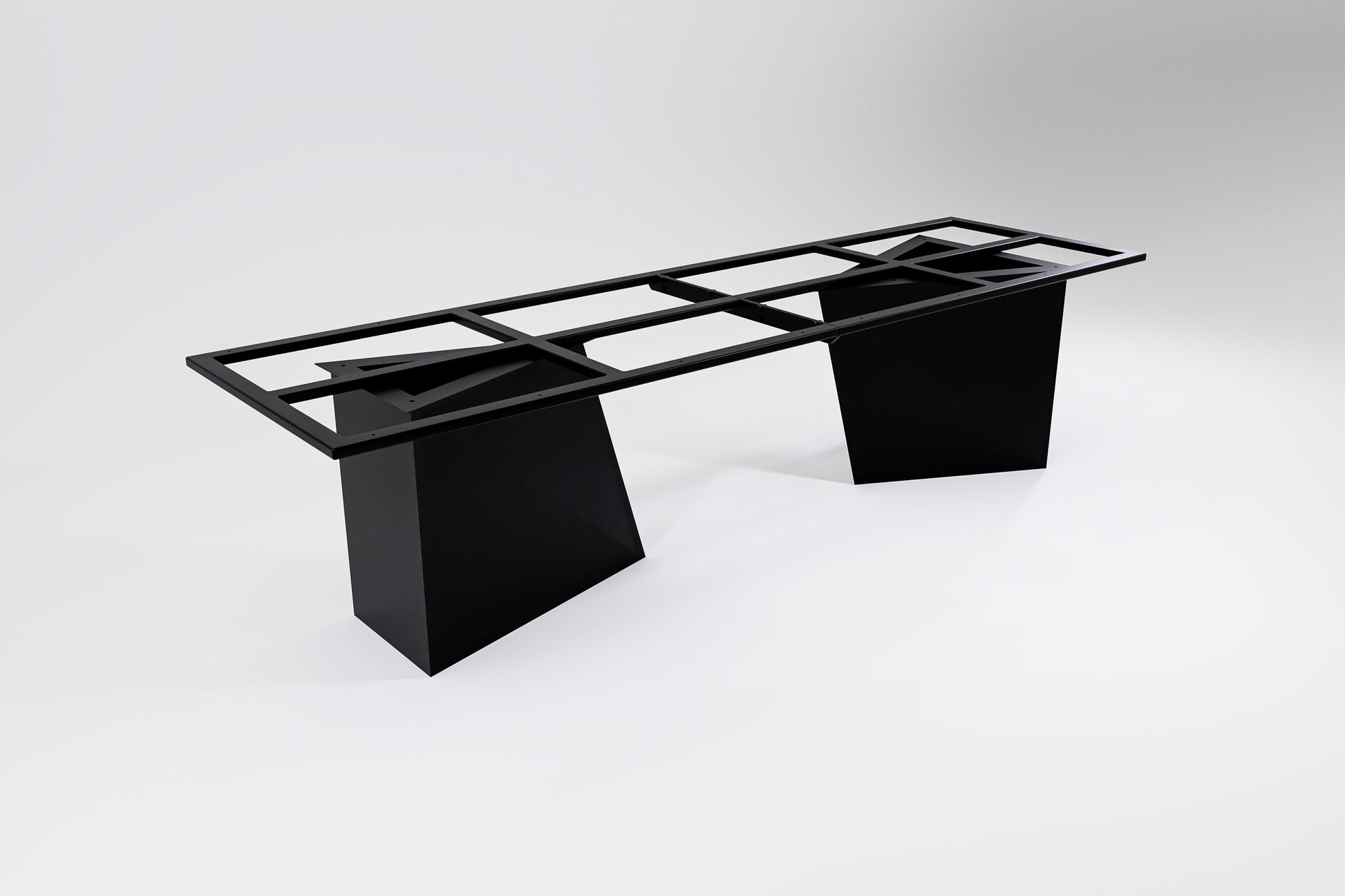 A modern table base with a geometric design, constructed from black steel with visible sub-frames and legs.