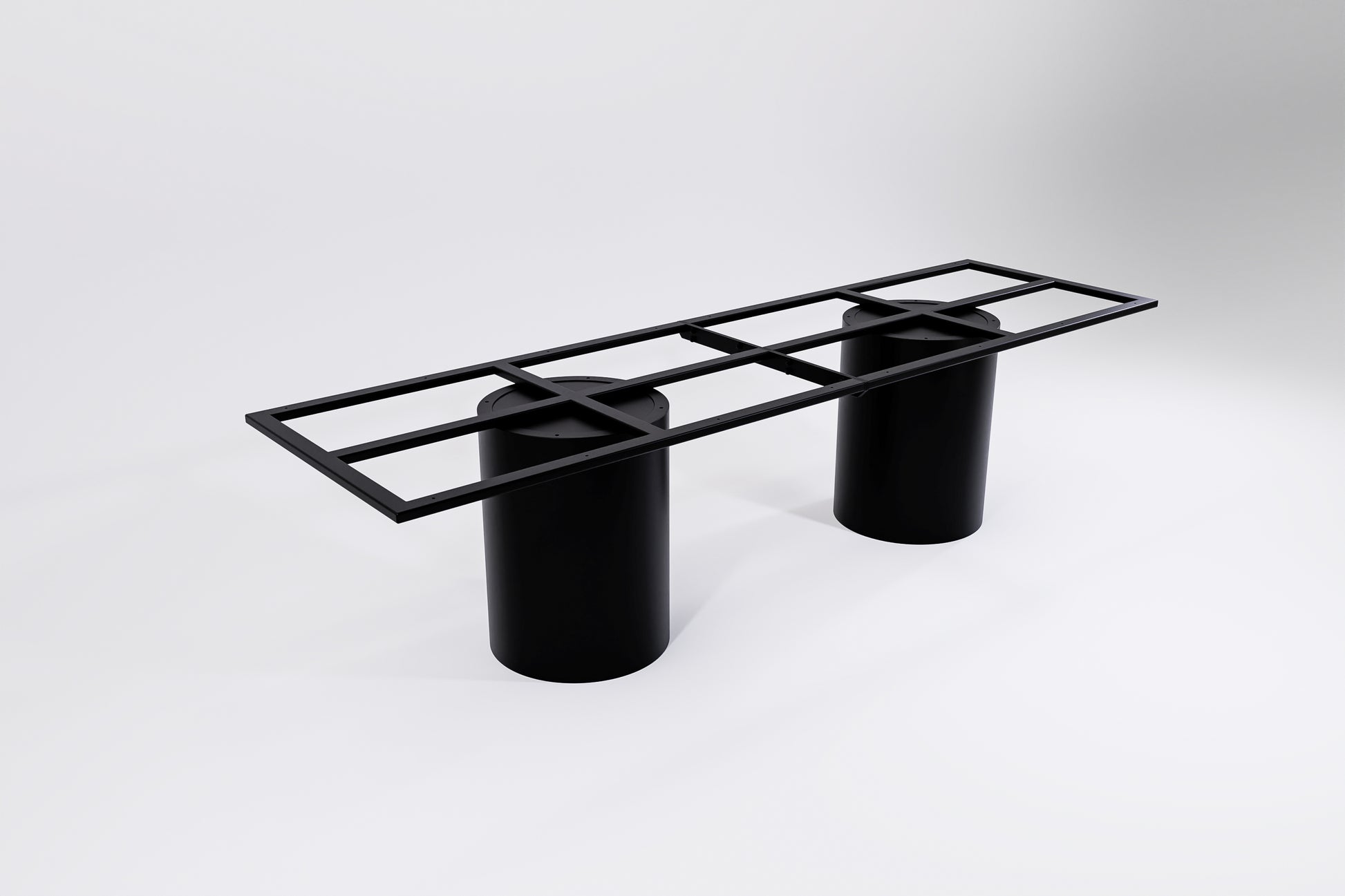 A black modular table base consisting of two cylindrical pedestal legs and a connecting frame.